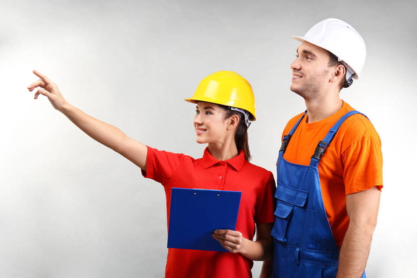 Warehouse workers with clipboard discussing something, on light background - Photo, Image