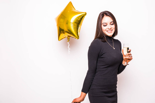 Altın yıldız ile siyah elbiseli genç ve güzel kadın şeklinde balon gülümseyen ve şampanya içmek - Fotoğraf, Görsel