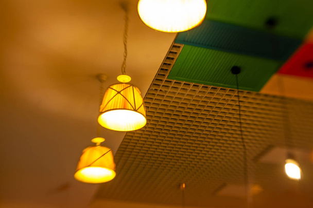 round stylish lampshades hang from colorful yellow, green and re - Photo, Image