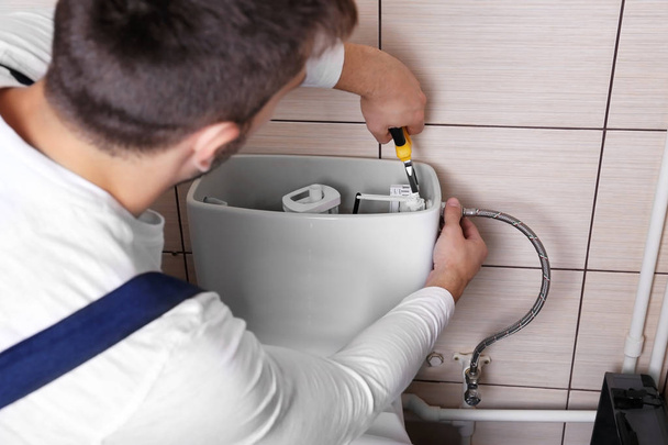 Plumber repairing toilet - Foto, Bild
