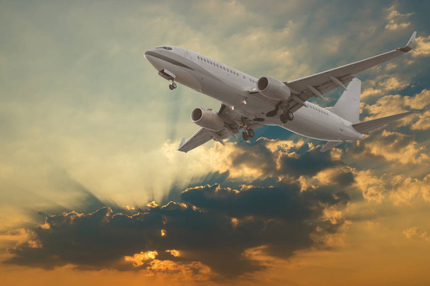 Комерційний літак, що літає з хмарами та сонячними променями фону
 - Фото, зображення
