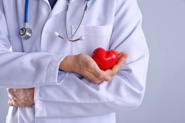 Male doctor holding red heart  - Foto, Bild