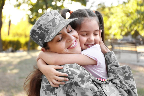 Woman in army uniform and her daughter in park - Foto, Bild