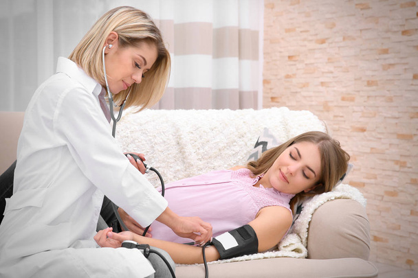 Gynecology consultation. Doctor measuring blood pressure of pregnant woman - Фото, зображення