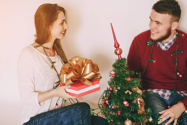loving couple decorating Christmas tree - Фото, изображение