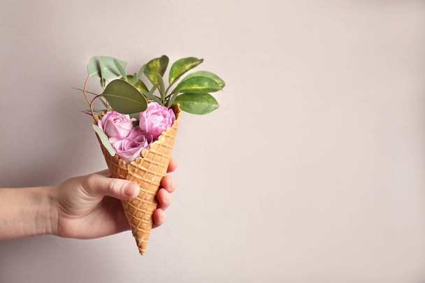 hand holding waffle cone with flowers - Foto, afbeelding