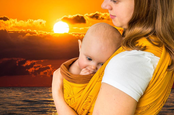 Madre feliz con su bebé en un cabestrillo
 - Foto, Imagen