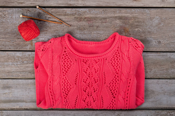 Ροζ πλεκτό πουλόβερ με το παλιό ξύλινο υπόβαθρο.  - Φωτογραφία, εικόνα