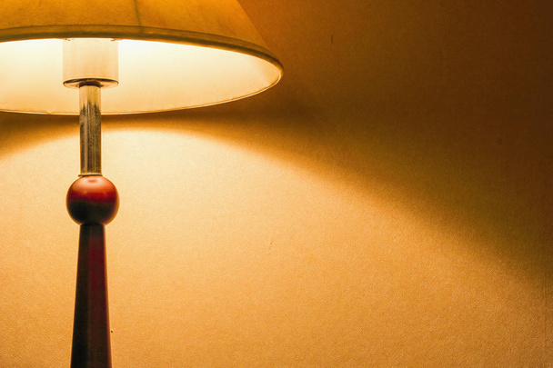 Lámpara en una mesa de luz junto a una cama
 - Foto, imagen