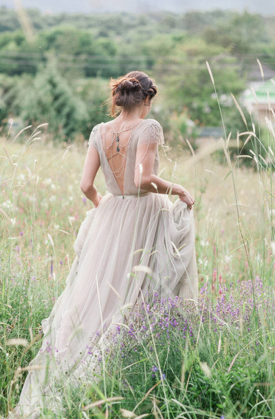 Bride in a beautiful dress with a bouquet of flowers and greener - Foto, imagen