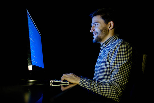 Software developer computer at dark home office - Photo, image