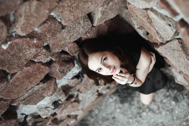 kaunis surullinen nuori nainen kiviseinällä tausta
 - Valokuva, kuva