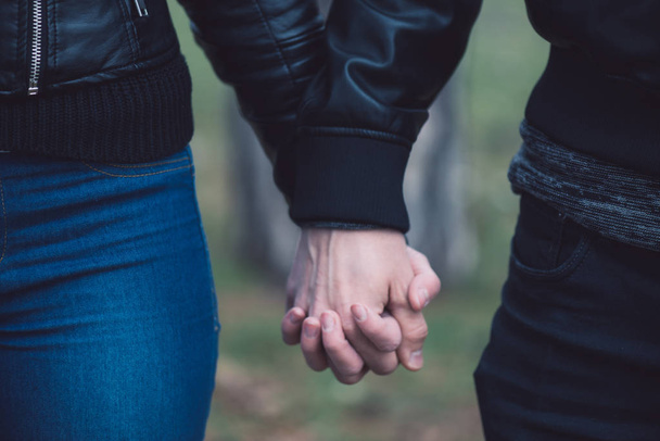Konceptuální obrázek ženské a mužské ruce dohromady. Mladý pár v lásce procházky v parku, drželi se za ruce. - Fotografie, Obrázek
