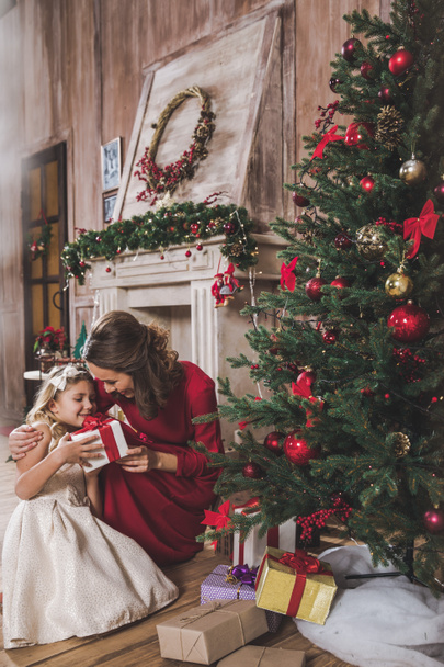 Mother giving daughter Christmas present  - 写真・画像
