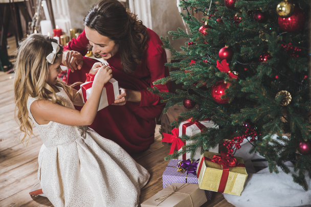 Mother giving daughter Christmas present  - Valokuva, kuva