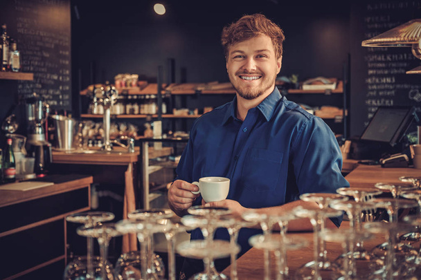 Knappe barista in zijn koffieshop - Foto, afbeelding