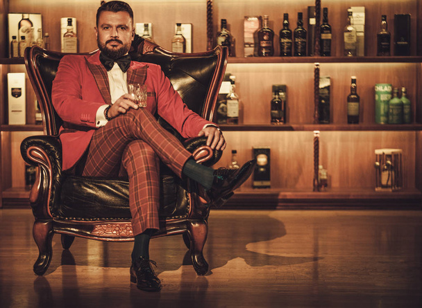 extravaganter stylischer Mann mit einem Glas Whisky  - Foto, Bild
