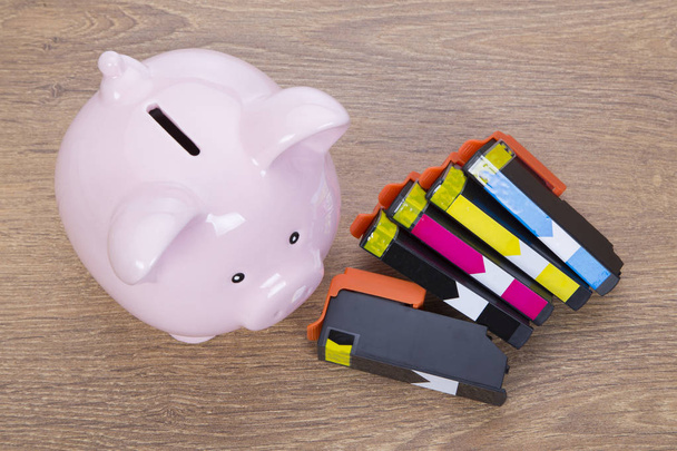Set of printer ink cartridges with a piggy bank - Photo, Image
