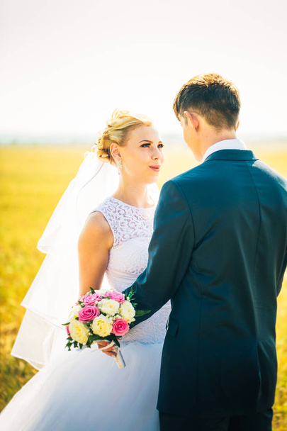 Braut und Bräutigam vor dem Hintergrund des Feldes - Foto, Bild