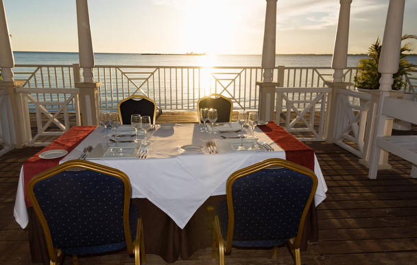 festive table in the gazebo at sunset - Photo, image