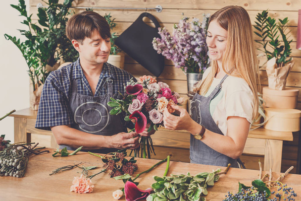 Florist and assistant in flower shop delivery make rose bouquet - Photo, Image