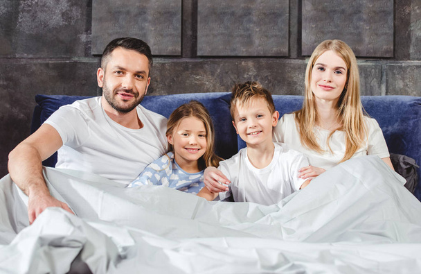 Happy family in bed     - Фото, зображення