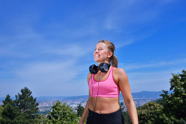 Success fitness winning woman concept with earphones. - Foto, Imagen