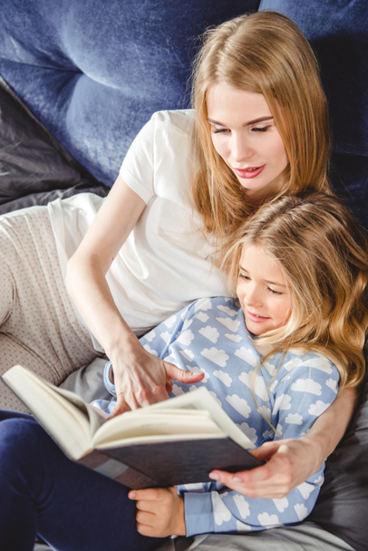 Mother and daughter reading book   - Valokuva, kuva