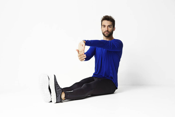 Man in sportswear stretching - Foto, afbeelding