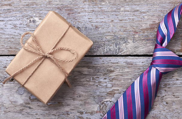 Gift box near striped necktie. - Photo, Image