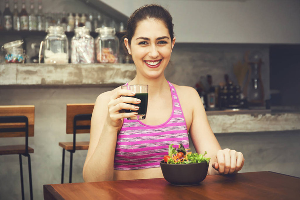 Attractive Caucasian fitness woman is eating salad with healthy glass of juice - Fitness and Diet concept - Fotoğraf, Görsel