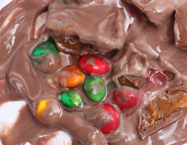 mistura doce de um pudim de chocolate, partes de um chocolate e balas coloridas
 - Foto, Imagem
