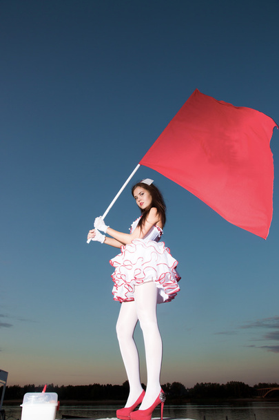 The young woman with a red flag - Фото, изображение