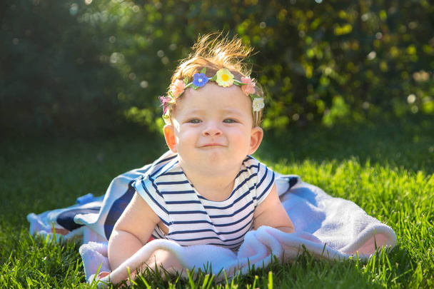 Mooie babymeisje op het groene gras. - Foto, afbeelding