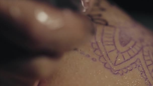 Close-up de mãos de tatuador em luvas tatuando um padrão no corpo macro
 - Filmagem, Vídeo