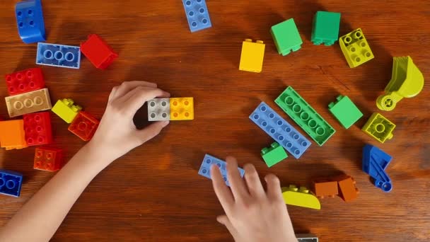 Girl playing in the colored blocks at the table - Footage, Video