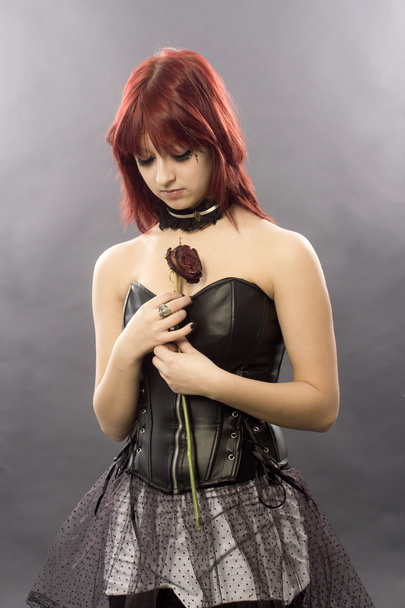 I costi da ragazza da capelli rossi con la rosa su asciugata
 - Foto, immagini
