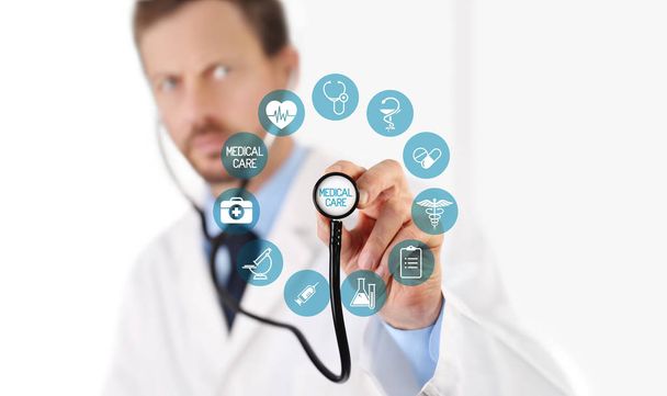 Medico con uno stetoscopio in mano e icone mediche su ghiaione
 - Foto, immagini