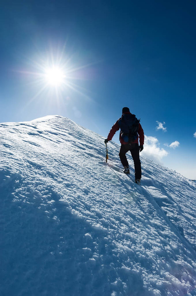 El montañista alcanza la cima de un pico nevado. Concepto: coraje, perseverancia, fuerza. Alpes suizos, Zermatt, Europa
. - Foto, Imagen