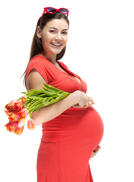 Gelukkig jonge zwangere vrouw in het rood - Foto, afbeelding