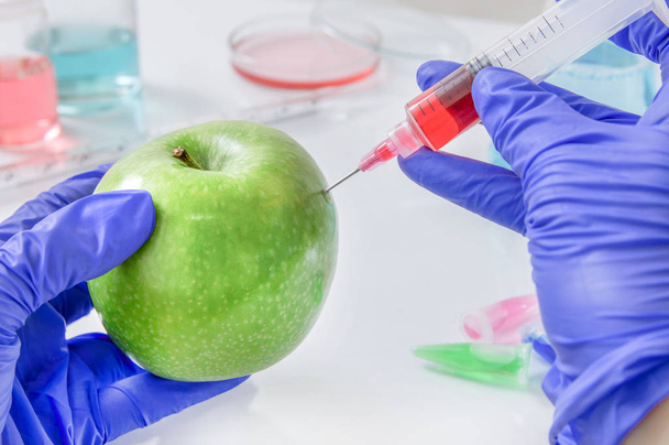 Vörös folyadék fecskendeznek az apple laboratóriumi fecskendő - Fotó, kép