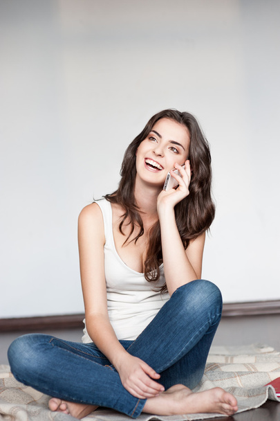 Young casual happy smiling brunette girl with cell phone - Foto, immagini