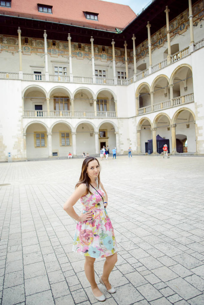Piękna dziewczyna podczas zwiedzania starego zamku w Krakowie, Wawel. - Zdjęcie, obraz
