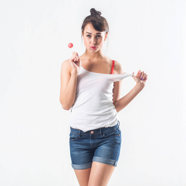 Young brunette model with lollipop  - Fotó, kép