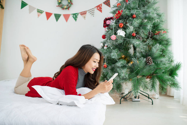 Asian woman using mobile phone on Christmas - Φωτογραφία, εικόνα