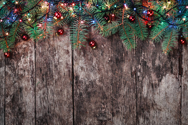 branches de sapin de Noël avec des lumières et des décorations rouges sur fond en bois. Composition de Noël et Bonne Année. Couché à plat, vue de dessus. Espace de copie
 - Photo, image