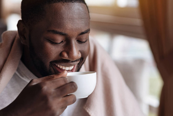 Delighted African American man enjoying the cup of tea - Fotografie, Obrázek