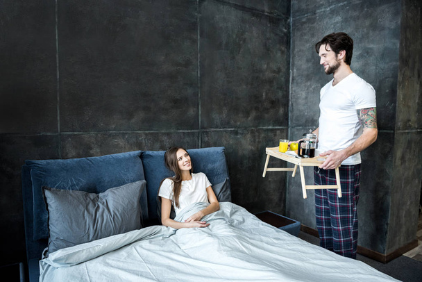 Man brings breakfast in bed - Photo, Image