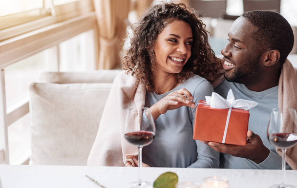 Caring African American man giving the present to his girlfriend - Zdjęcie, obraz