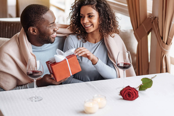 Delighted African American man giving the box to his girlfriend - Photo, Image